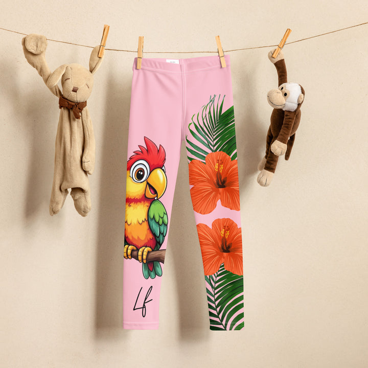  Jungle Parrot Girls Leggings, light pink background with a red, yellow, orange, and green parrot standing on a branch on one leg, and green jungle leaves with two large orange flowers running down the other leg, front view on hanger