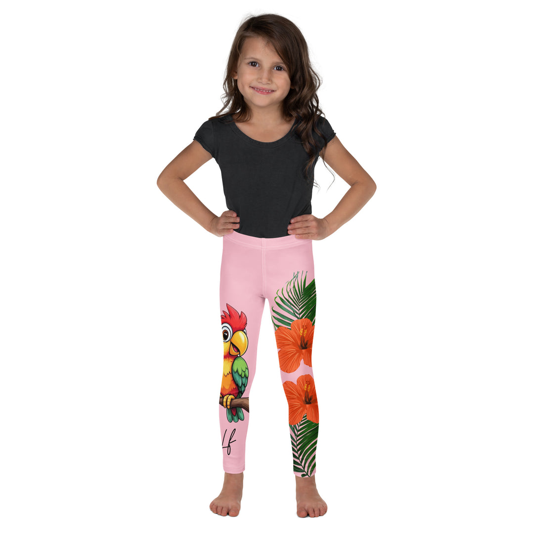 Jungle Parrot Girls Leggings, light pink background with a red, yellow, orange, and green parrot standing on a branch on one leg, and green jungle leaves with two large orange flowers running down the other leg, front view on model
