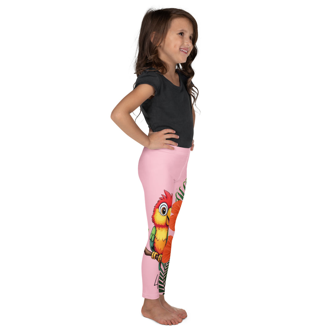  Jungle Parrot Girls Leggings, light pink background with a red, yellow, orange, and green parrot standing on a branch on one leg, and green jungle leaves with two large orange flowers running down the other leg, right side view on model