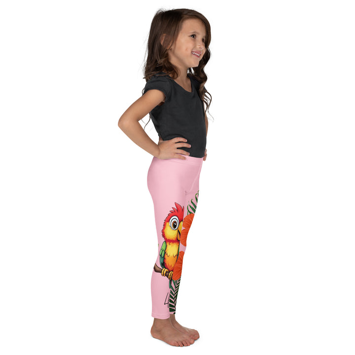  Jungle Parrot Girls Leggings, light pink background with a red, yellow, orange, and green parrot standing on a branch on one leg, and green jungle leaves with two large orange flowers running down the other leg, right side view on model