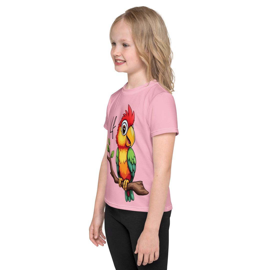 Jungle Parrot Girls T-shirt, light pink background with a red, yellow, orange, and green parrot standing on a branch on the front, left side view on model