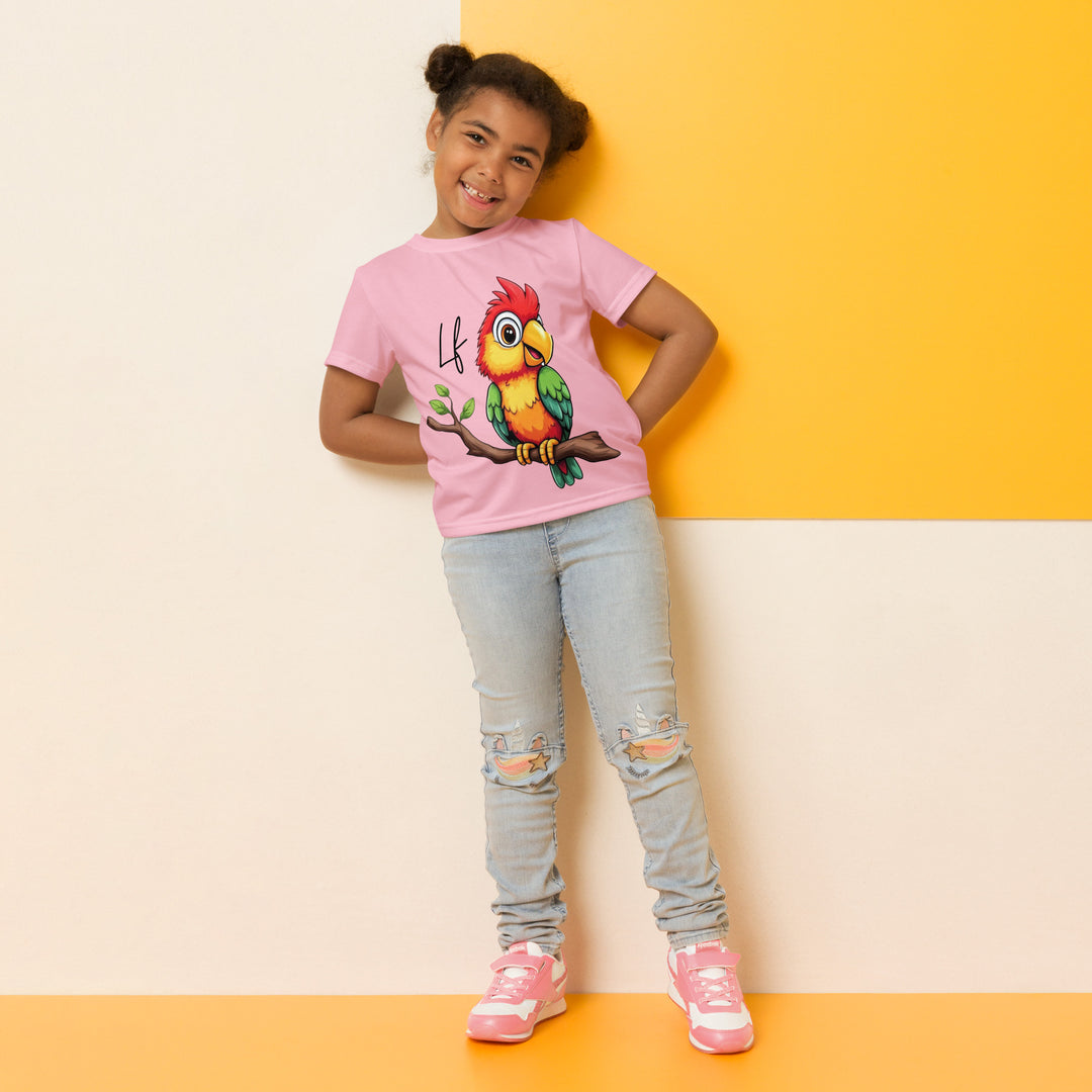 Jungle Parrot Girls T-shirt, light pink background with a red, yellow, orange, and green parrot standing on a branch on the front, relaxed front pose on model