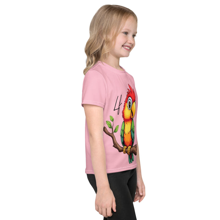 Jungle Parrot Girls T-shirt, light pink background with a red, yellow, orange, and green parrot standing on a branch on the front, right side view on model