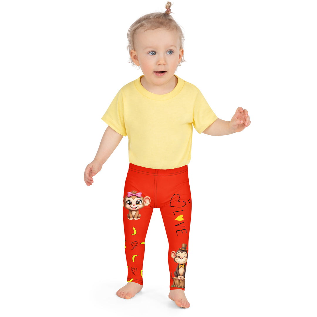  Love Monkey Girls Leggings, red background with a smiling female monkey with big eyes and a pink bow on the head at the top of one leg, yellow bananas with black drawn hearts below, and a winking male monkey wearing a hat sitting on a tree stump near the bottom of the other leg, with the word "LOVE" above, front close-up view on model