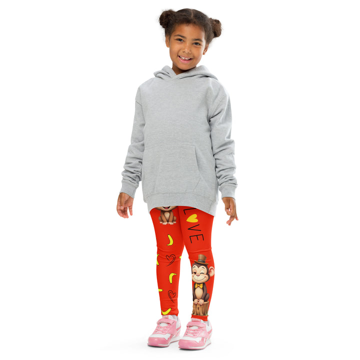  Love Monkey Girls Leggings, red background with a smiling female monkey with big eyes and a pink bow on the head at the top of one leg, yellow bananas with black drawn hearts below, and a winking male monkey wearing a hat sitting on a tree stump near the bottom of the other leg, with the word "LOVE" above, front pose with arms at sides on model