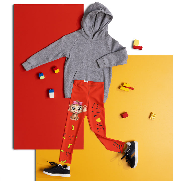 Love Monkey Girls Leggings, red background with a smiling female monkey with big eyes and a pink bow on the head at the top of one leg, yellow bananas with black drawn hearts below, and a winking male monkey wearing a hat sitting on a tree stump near the bottom of the other leg, with the word "LOVE" above, front view laid flat on floor