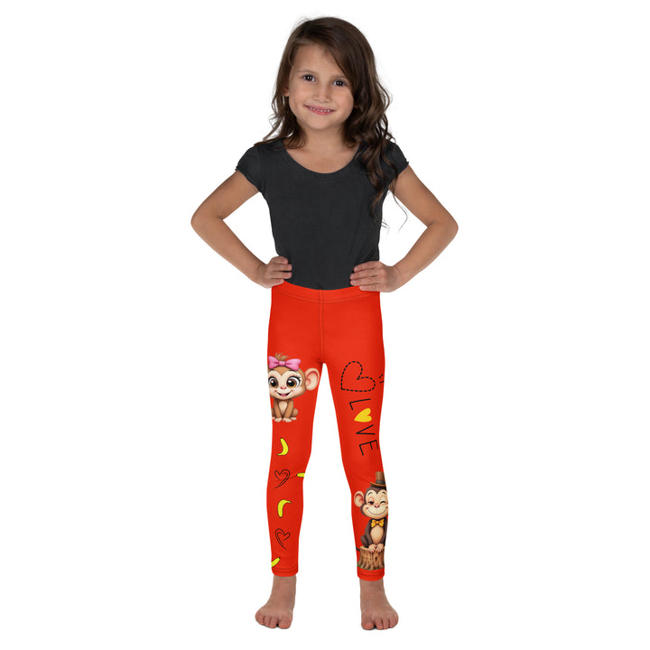 Love Monkey Girls Leggings, red background with a smiling female monkey with big eyes and a pink bow on the head at the top of one leg, yellow bananas with black drawn hearts below, and a winking male monkey wearing a hat sitting on a tree stump near the bottom of the other leg, with the word "LOVE" above, front view on model
