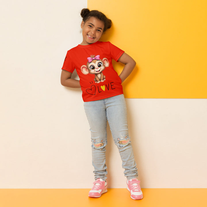 Love Monkey Girls T-shirt, red background with a smiling female monkey with a pink bow on her head and big eyes, sitting on a black "LOVE" text with a black and yellow heart, relaxed front pose on model