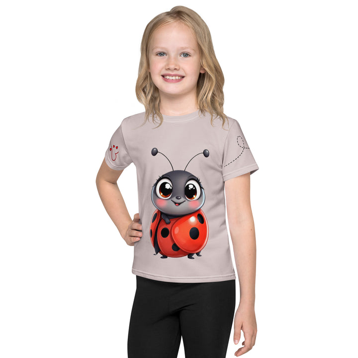  Lovebugs Girls T-shirt, sand-colored background with a smiling female ladybug with big eyes on the front, a happy male ladybug with a heart beside him on the back, and hearts with connecting lines on both sleeves, front view on model