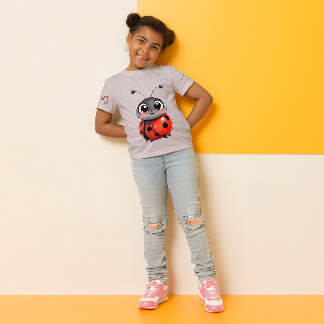  Lovebugs Girls T-shirt, sand-colored background with a smiling female ladybug with big eyes on the front, a happy male ladybug with a heart beside him on the back, and hearts with connecting lines on both sleeves, relaxed front pose on model