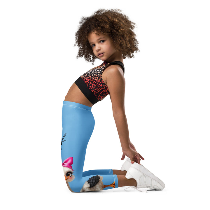 Mama & Me Ostrich Girls Leggings, sky blue background with a large white mother ostrich wearing a pink bow on her head on one leg, "MOM" text in black and pink above, and a smaller white daughter ostrich with black wings and a pink bow on her head on the other leg, left side view kneeling on model