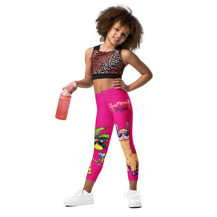 Palma Llama Girls Leggings, pink background with a palm tree wearing sunglasses and holding a cocktail on one leg, and a llama with sunglasses and "SUMMER VIBES" text above on the other leg, designs covering almost the full length of each leg, relaxed front pose on model