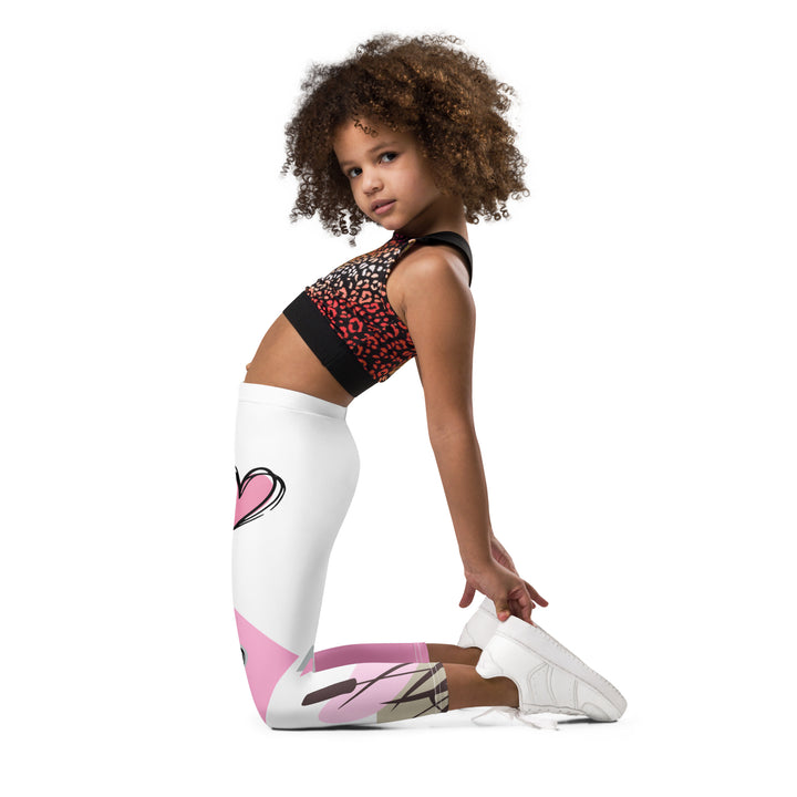 Pastel Elephant Love Girls Leggings, white background with gray elephant holding a pink heart-shaped balloon, surrounded by gray and pink hearts, pink and gray rectangles, and floral accents in matching colors, left side view kneeling on model