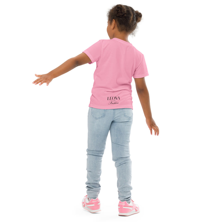Pony Cool Girls T-shirt – back angle with one arm extended to the side on model, pink with black pony wearing yellow sunglasses and small colorful stars-with a visible 'Leona Fashion' text on the design