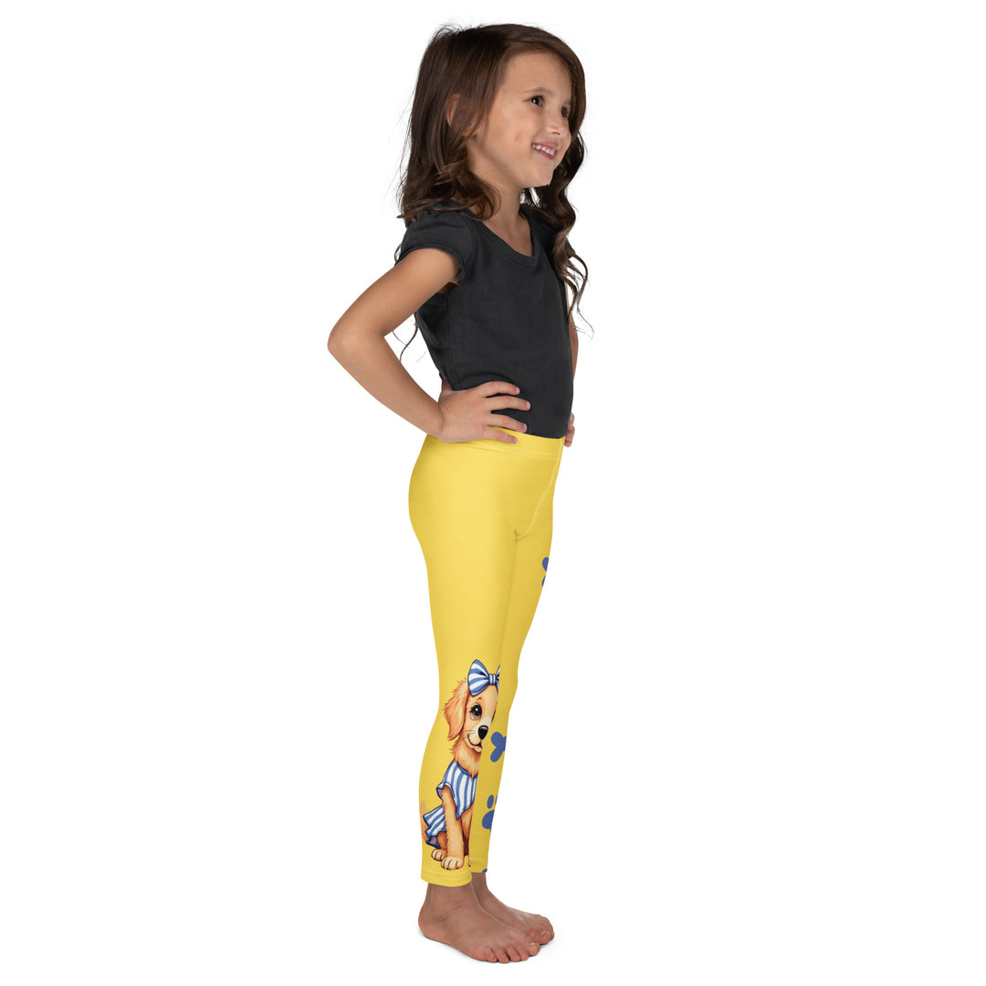 Puppy & Bones Girls Leggings, yellow background with a golden retriever puppy wearing a blue and white striped outfit and a matching blue and white bow on the head on one leg, and blue paw prints and blue bones running down the other leg, right side view on model
