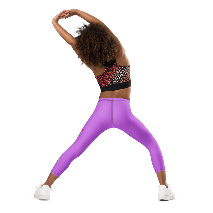 Purple Baby Ostrich Girls Leggings, purple background with a white and gray baby ostrich girl featuring a pink bow on her head extending almost the full length of one leg, back angle with relaxed pose on model
