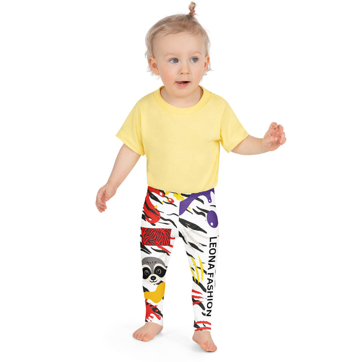 Raccoon Bandit Glow Girls Leggings, white base with splash-like spots in red, purple, and yellow, gray raccoon head, and wavy black stripes, front close-up view on model-with a visible 'Leona Fashion' text on the design