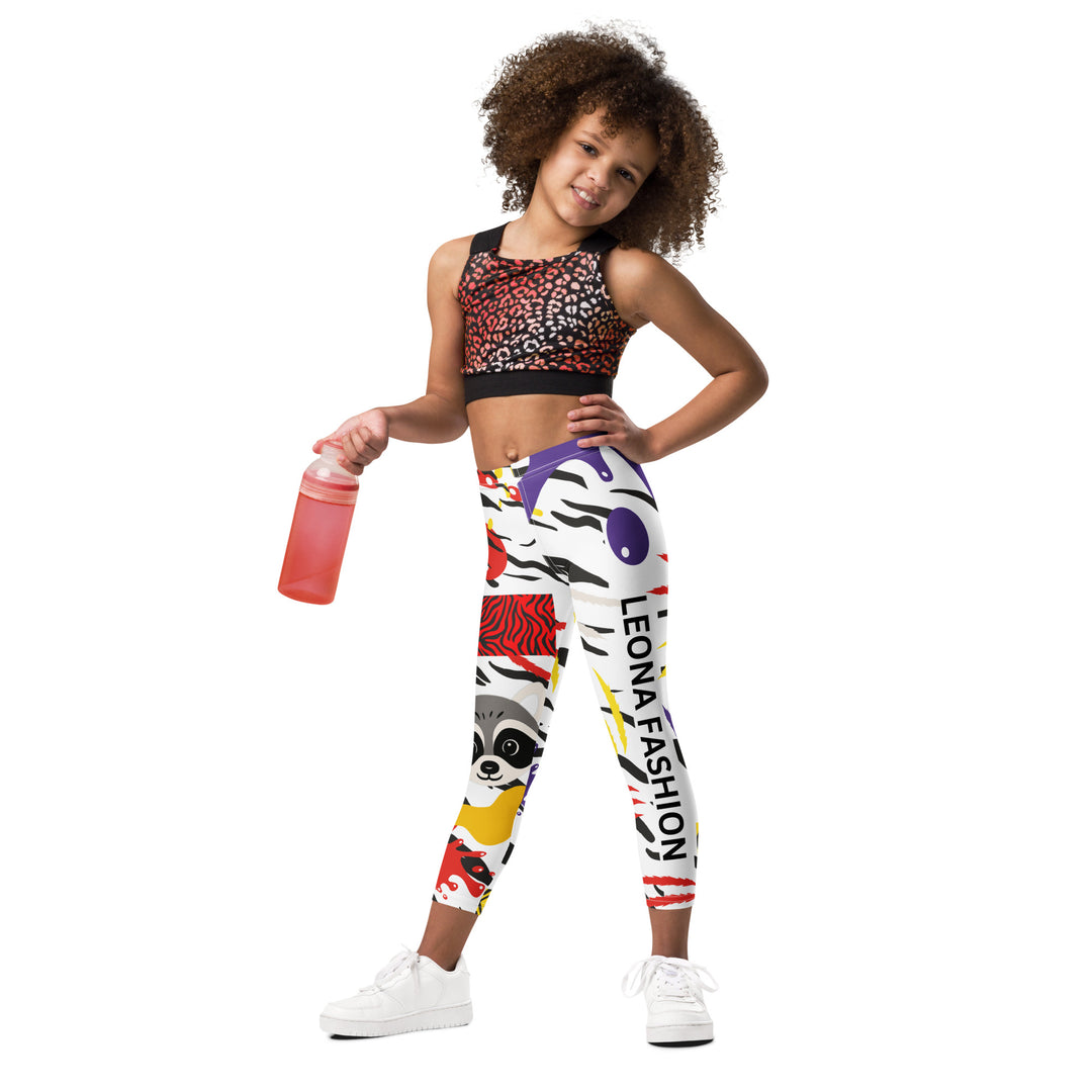 Raccoon Bandit Glow Girls Leggings, white base with splash-like spots in red, purple, and yellow, gray raccoon head, and wavy black stripes, front view on model-with a visible 'Leona Fashion' text on the design