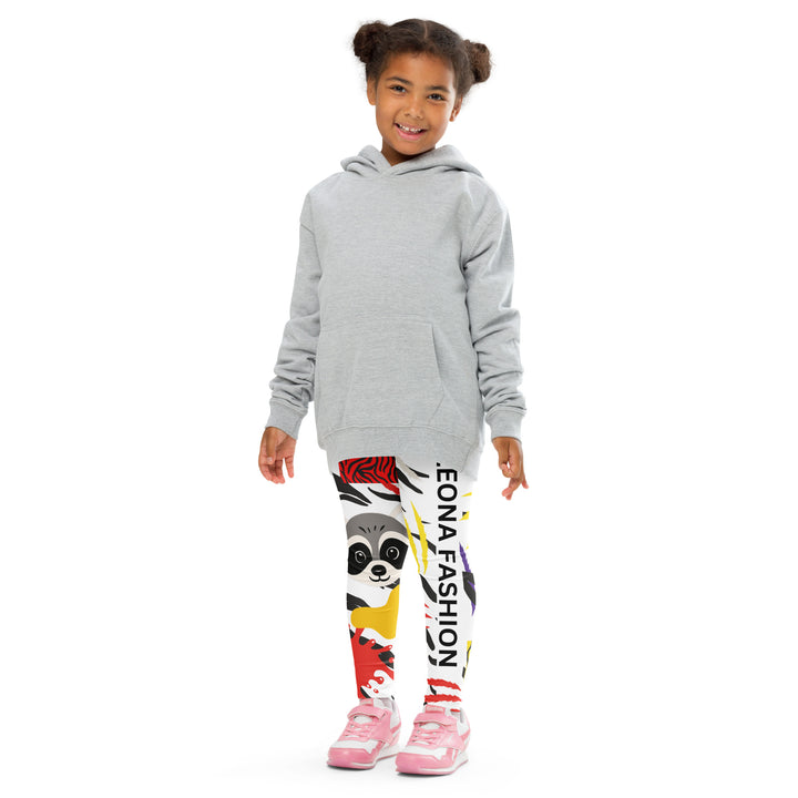 Raccoon Bandit Glow Girls Leggings, white base with splash-like spots in red, purple, and yellow, gray raccoon head, and wavy black stripes, front pose with arms extended on model-with a visible 'Leona Fashion' text on the design