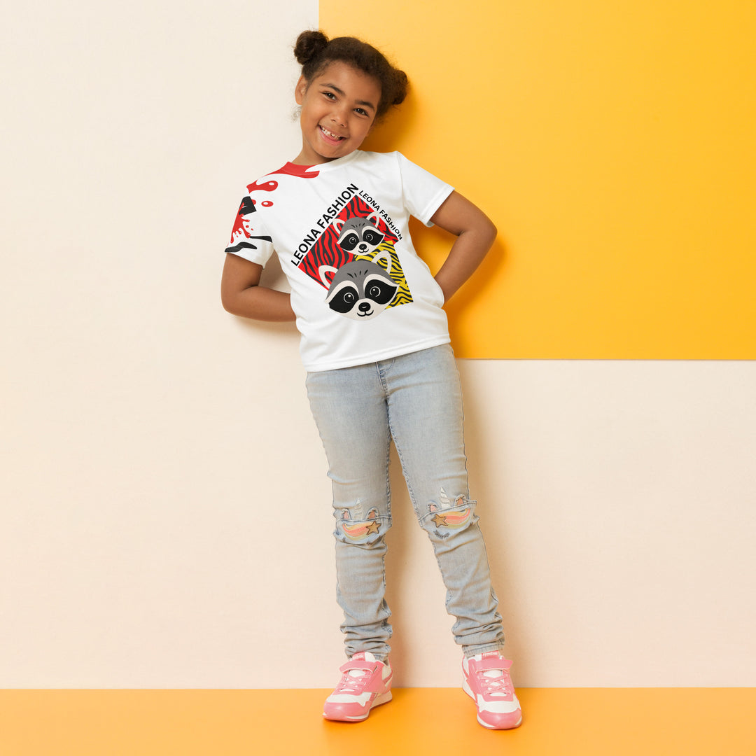  Raccoon Bandit Glow Girls T-shirt, white background with two gray raccoons inside red and yellow rectangular patterns with black stripes, red and black splash detail on right sleeve and neckline, relaxed front pose on model-with a visible 'Leona Fashion' text on the design