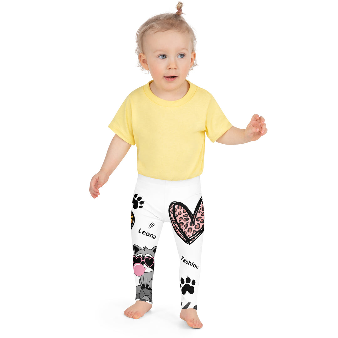 Raccoon Love Girls Leggings, white background with gray raccoon blowing a pink bubble gum sitting on a rock, pink tiger-striped heart, claws, and animal paw details, front view on model-with a visible 'Leona Fashion' text on the design