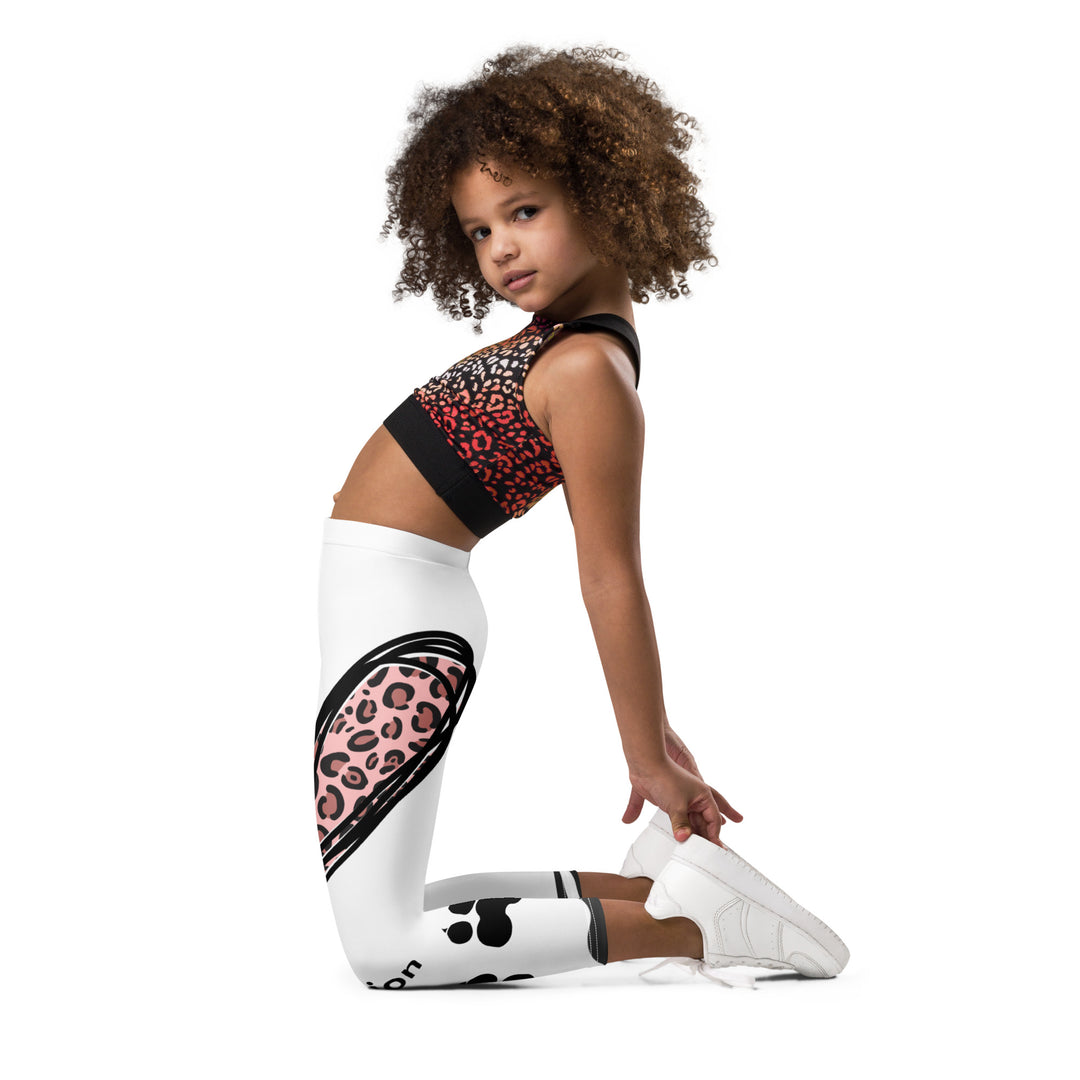 Raccoon Love Girls Leggings, white background with gray raccoon blowing a pink bubble gum sitting on a rock, pink tiger-striped heart, claws, and animal paw details, left side view kneeling on model