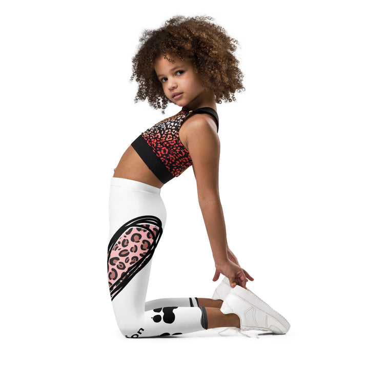 Raccoon Love Girls Leggings, white background with gray raccoon blowing a pink bubble gum sitting on a rock, pink tiger-striped heart, claws, and animal paw details, left side view kneeling on model
