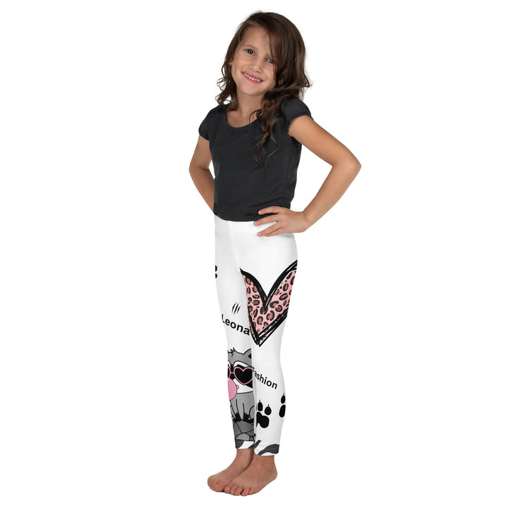 Raccoon Love Girls Leggings, white background with gray raccoon blowing a pink bubble gum sitting on a rock, pink tiger-striped heart, claws, and animal paw details, left side view on model-with a visible 'Leona Fashion' text on the design