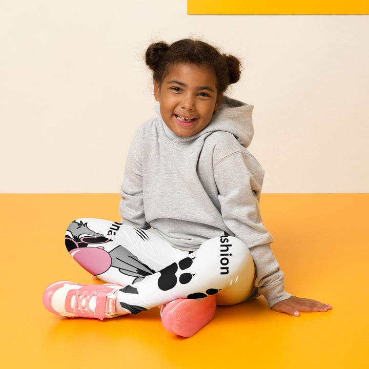 Raccoon Love Girls Leggings, white background with gray raccoon blowing a pink bubble gum sitting on a rock, pink tiger-striped heart, claws, and animal paw details, seated pose on model-with a visible 'Leona Fashion' text on the design