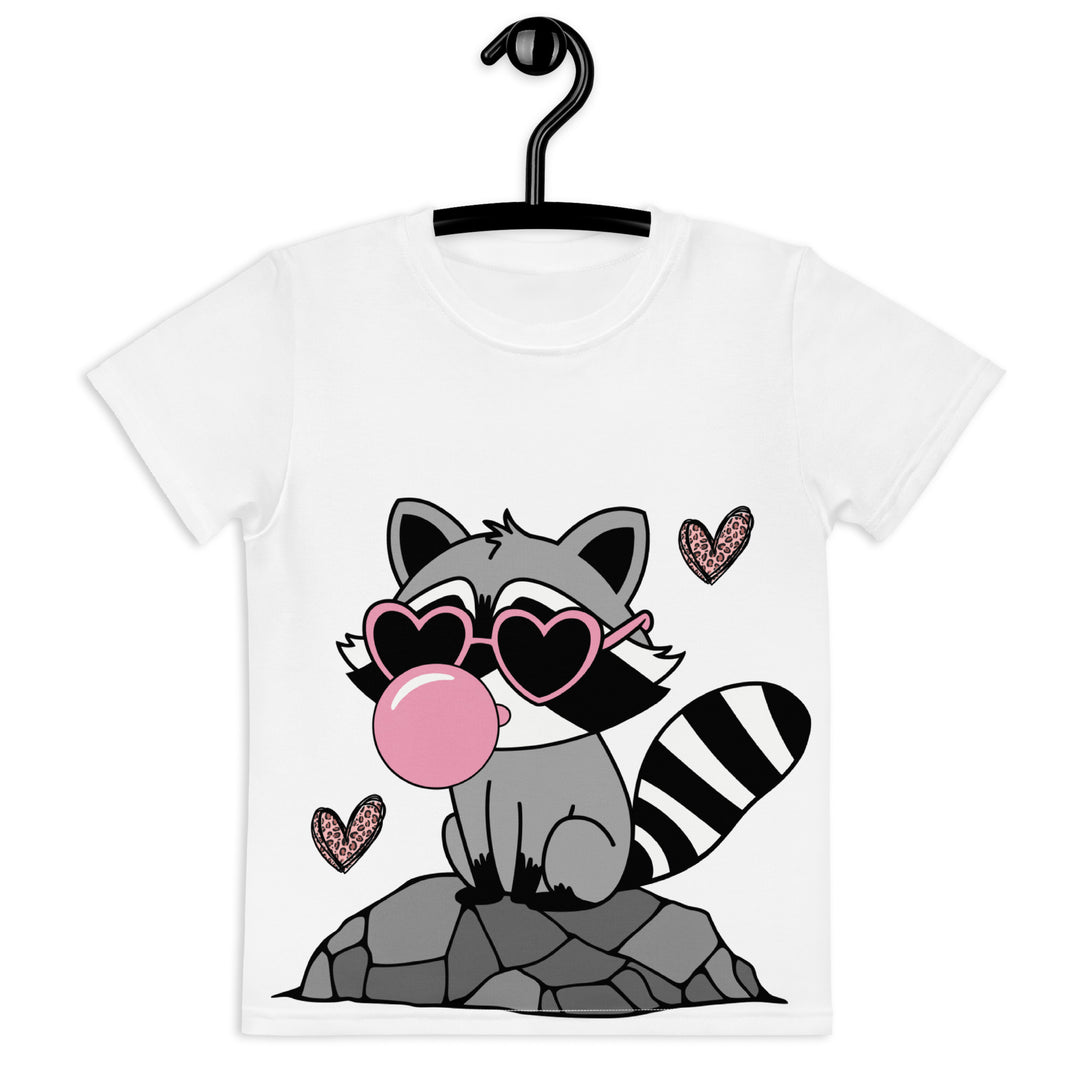 Raccoon Love Girls T-shirt – front view on hanger, white with gray raccoon standing on a rock blowing a pink bubble gum, wearing pink heart-shaped sunglasses, surrounded by pink tiger-striped hearts