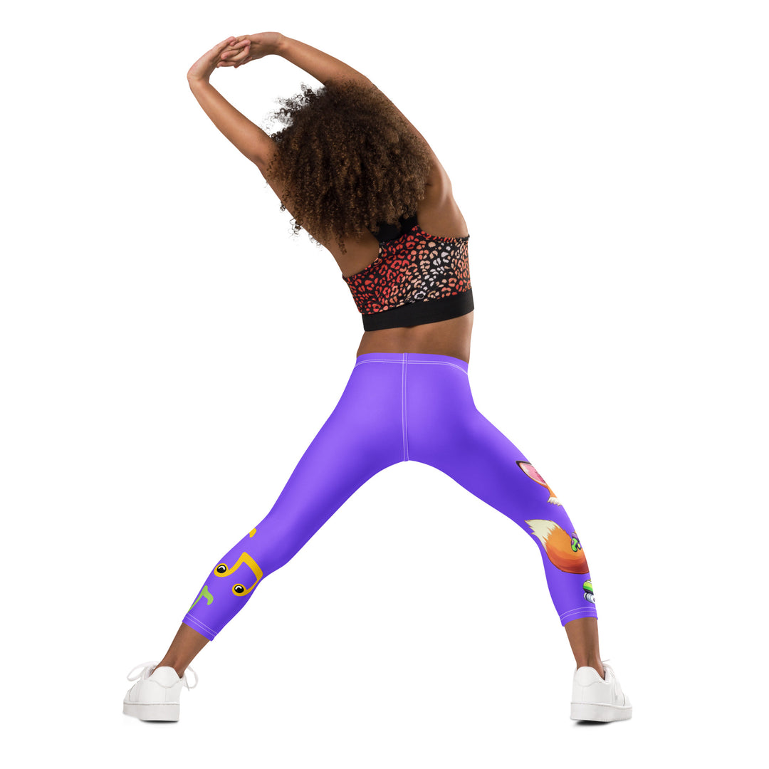 Roller Fox Girls Leggings, purple background with an orange fox wearing purple and neon green sportswear and neon green roller skates on one leg, "GOOD VIBES" text in white above, and orange-green butterflies and orange, green, and white music notes on the other leg, back angle with relaxed pose on model