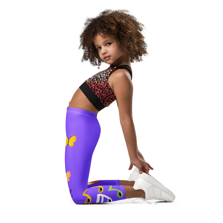 Roller Fox Girls Leggings, purple background with an orange fox wearing purple and neon green sportswear and neon green roller skates on one leg, "GOOD VIBES" text in white above, and orange-green butterflies and orange, green, and white music notes on the other leg, left side view kneeling on model