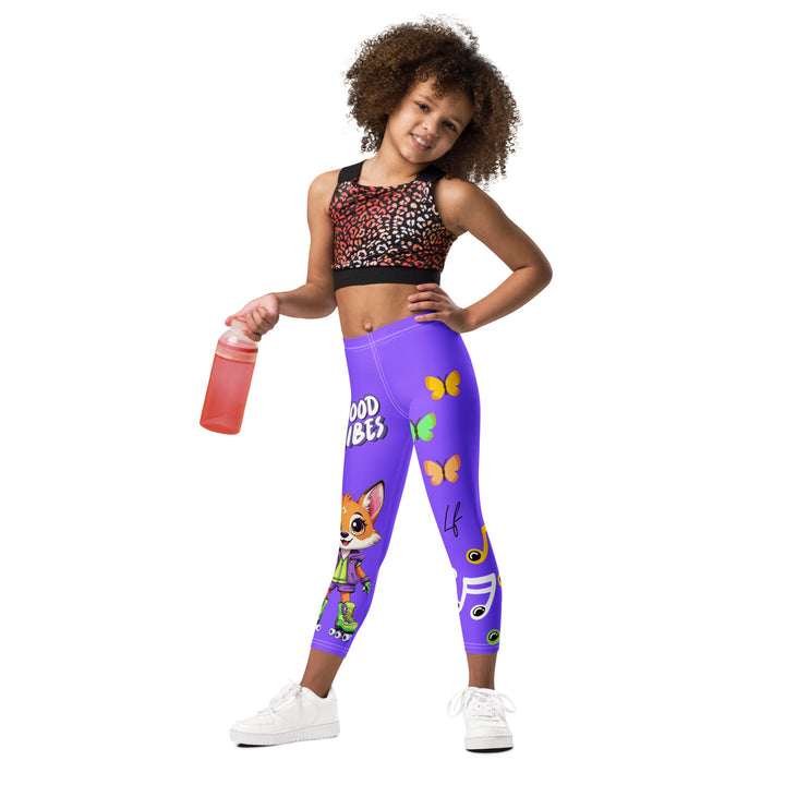 Roller Fox Girls Leggings, purple background with an orange fox wearing purple and neon green sportswear and neon green roller skates on one leg, "GOOD VIBES" text in white above, and orange-green butterflies and orange, green, and white music notes on the other leg, relaxed front pose on model