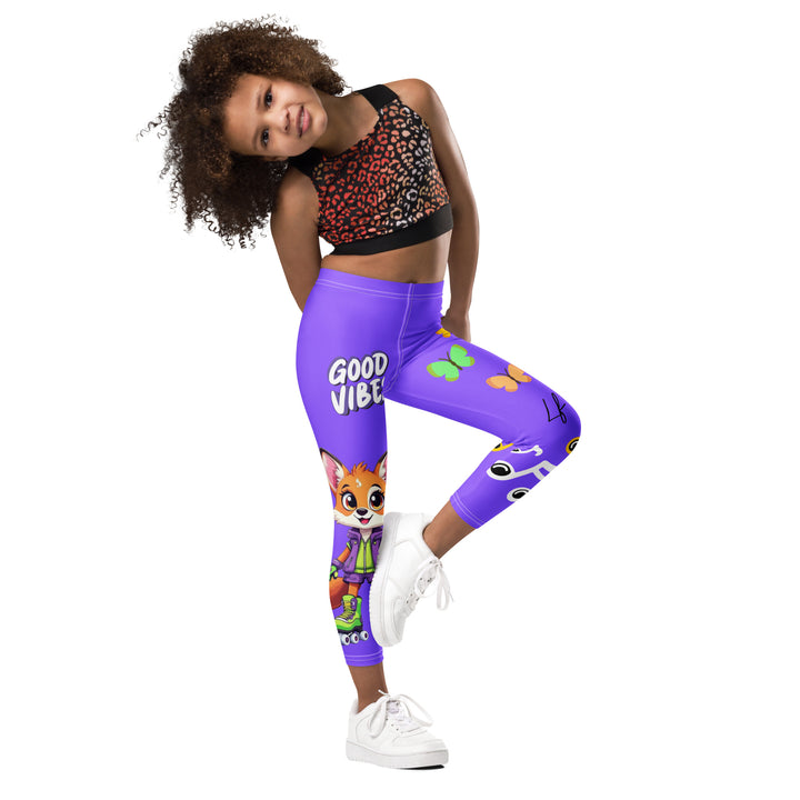  Roller Fox Girls Leggings, purple background with an orange fox wearing purple and neon green sportswear and neon green roller skates on one leg, "GOOD VIBES" text in white above, and orange-green butterflies and orange, green, and white music notes on the other leg, side view with one leg lifted and bent on model