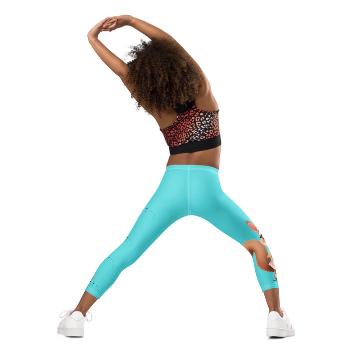 Skate Squirrel Girls Leggings, pastel blue background with a squirrel wearing a pink dress and ice skates on one leg, pastel pink and blue hearts with pink skates on the other leg, and black sparkling star details winding between the elements, back angle with relaxed pose on model