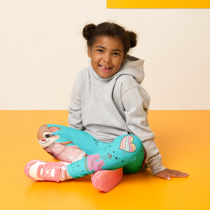  Skate Squirrel Girls Leggings, pastel blue background with a squirrel wearing a pink dress and ice skates on one leg, pastel pink and blue hearts with pink skates on the other leg, and black sparkling star details winding between the elements, seated pose on model