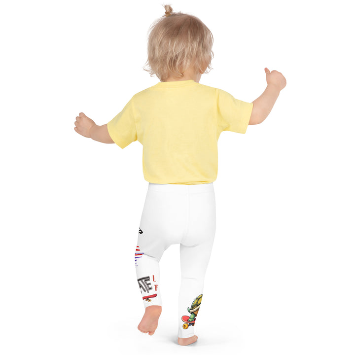 Skater Turtle Girls Leggings, white background with a green turtle riding a skateboard on one leg, black "MAKE YOUR MOVE" text and black skater silhouette with pink and purple motion lines on the other leg, and a skateboard with "skate" text at the bottom of the leg, back pose on model