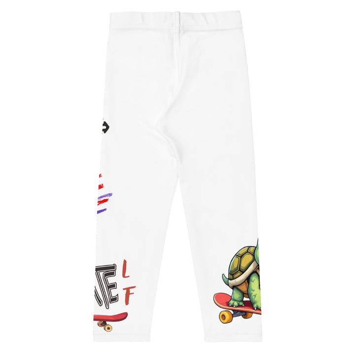 Skater Turtle Girls Leggings, white background with a green turtle riding a skateboard on one leg, black "MAKE YOUR MOVE" text and black skater silhouette with pink and purple motion lines on the other leg, and a skateboard with "skate" text at the bottom of the leg, back view