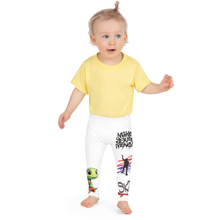 Skater Turtle Girls Leggings, white background with a green turtle riding a skateboard on one leg, black "MAKE YOUR MOVE" text and black skater silhouette with pink and purple motion lines on the other leg, and a skateboard with "skate" text at the bottom of the leg, front close-up view on model