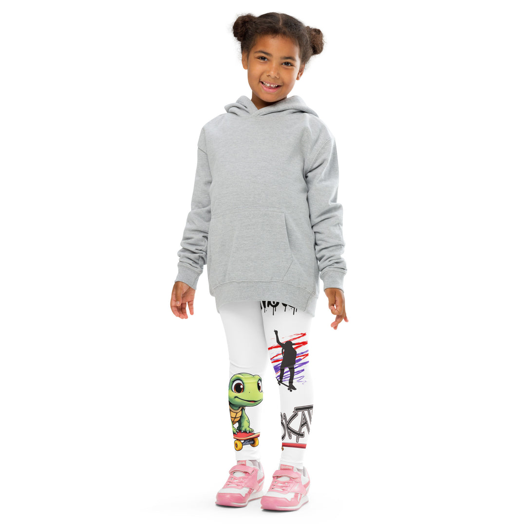 Skater Turtle Girls Leggings, white background with a green turtle riding a skateboard on one leg, black "MAKE YOUR MOVE" text and black skater silhouette with pink and purple motion lines on the other leg, and a skateboard with "skate" text at the bottom of the leg, front pose with arms at sides on model