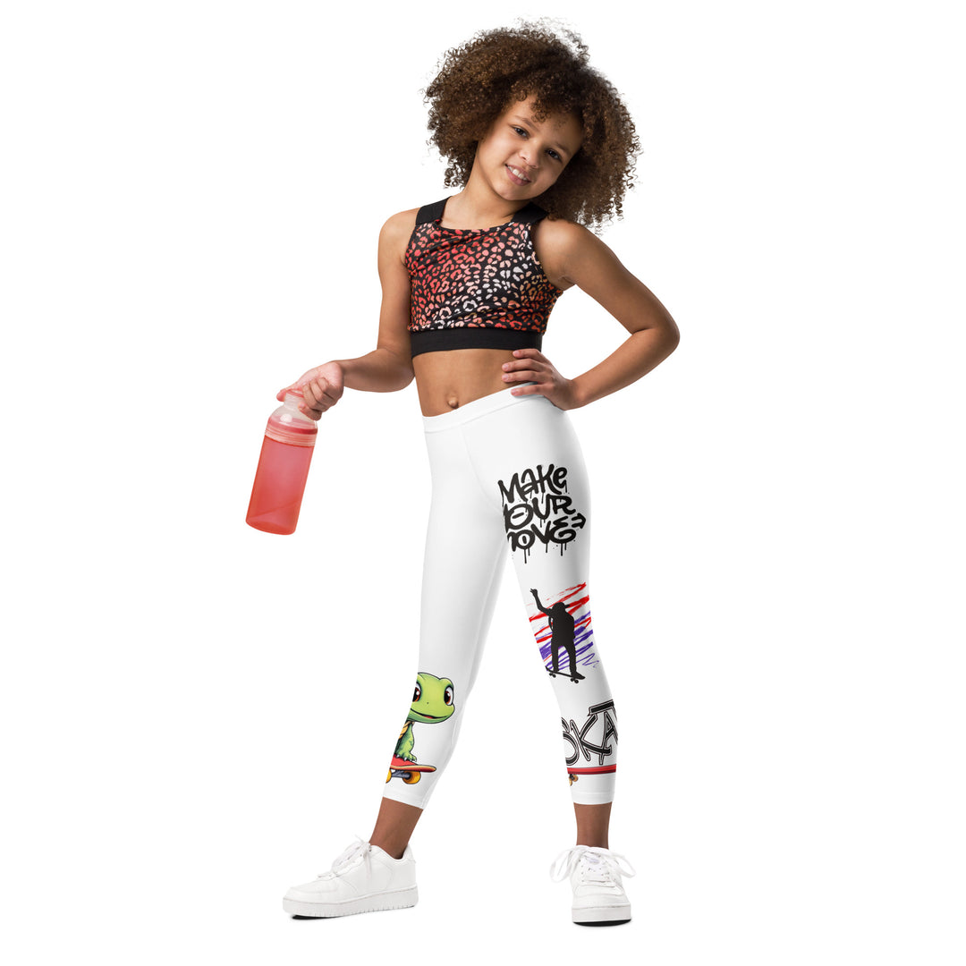 Skater Turtle Girls Leggings, white background with a green turtle riding a skateboard on one leg, black "MAKE YOUR MOVE" text and black skater silhouette with pink and purple motion lines on the other leg, and a skateboard with "skate" text at the bottom of the leg, relaxed front pose on model
