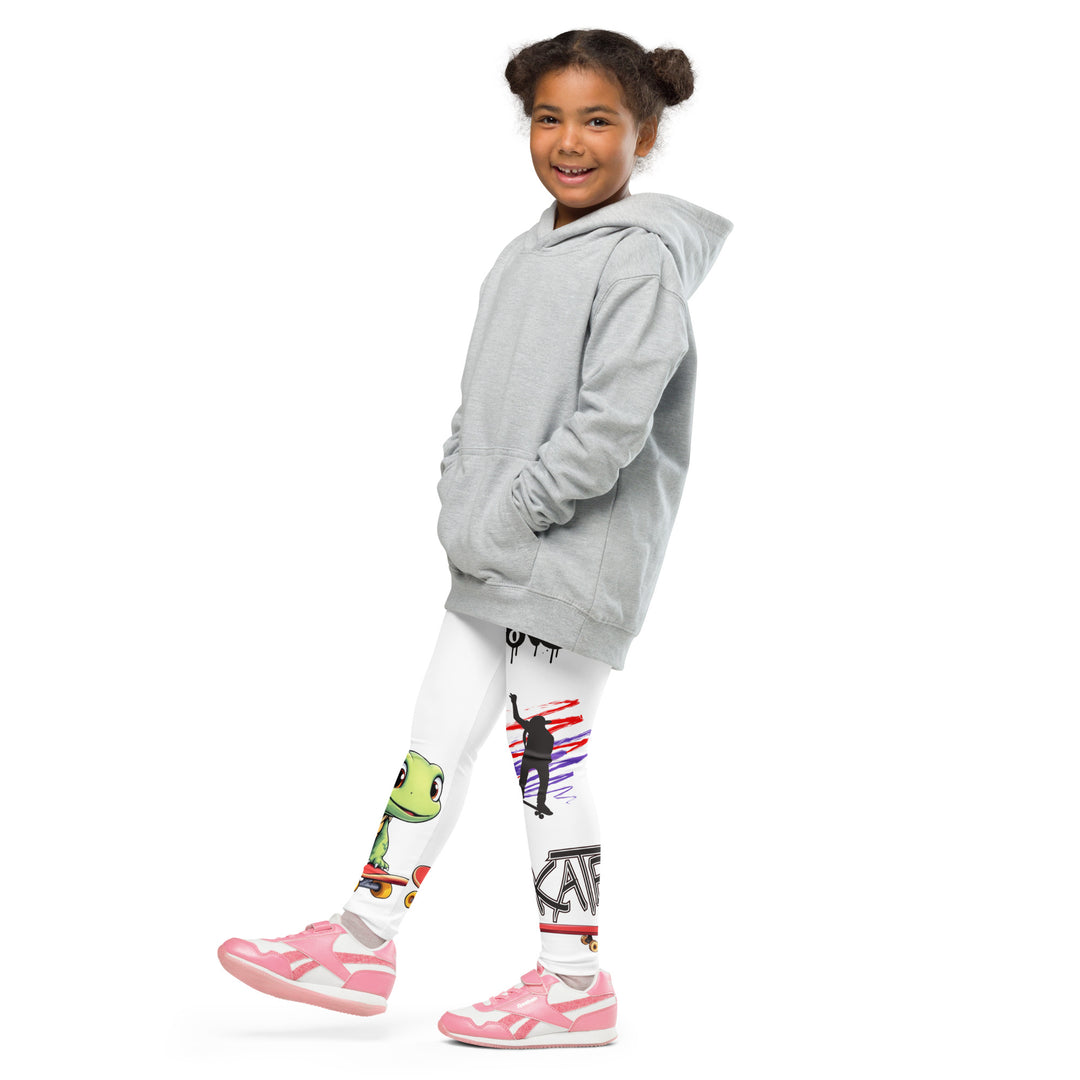Skater Turtle Girls Leggings, white background with a green turtle riding a skateboard on one leg, black "MAKE YOUR MOVE" text and black skater silhouette with pink and purple motion lines on the other leg, and a skateboard with "skate" text at the bottom of the leg, side view with one leg lifted and extended on model