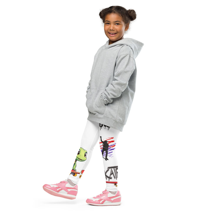 Skater Turtle Girls Leggings, white background with a green turtle riding a skateboard on one leg, black "MAKE YOUR MOVE" text and black skater silhouette with pink and purple motion lines on the other leg, and a skateboard with "skate" text at the bottom of the leg, side view with one leg lifted and extended on model