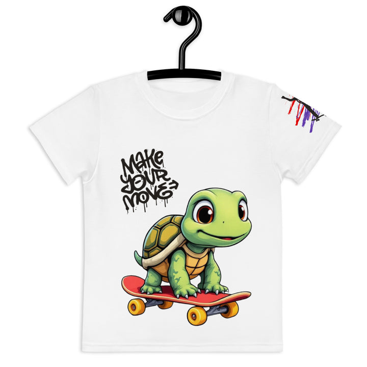  Skater Turtle Girls T-shirt, white background with a green turtle on a skateboard and black "MAKE YOUR MOVE" text on the front, black skater silhouette with pink and purple motion lines on the left sleeve, and a skateboard with "SKATE" text at the bottom back of the shirt, front view on hanger