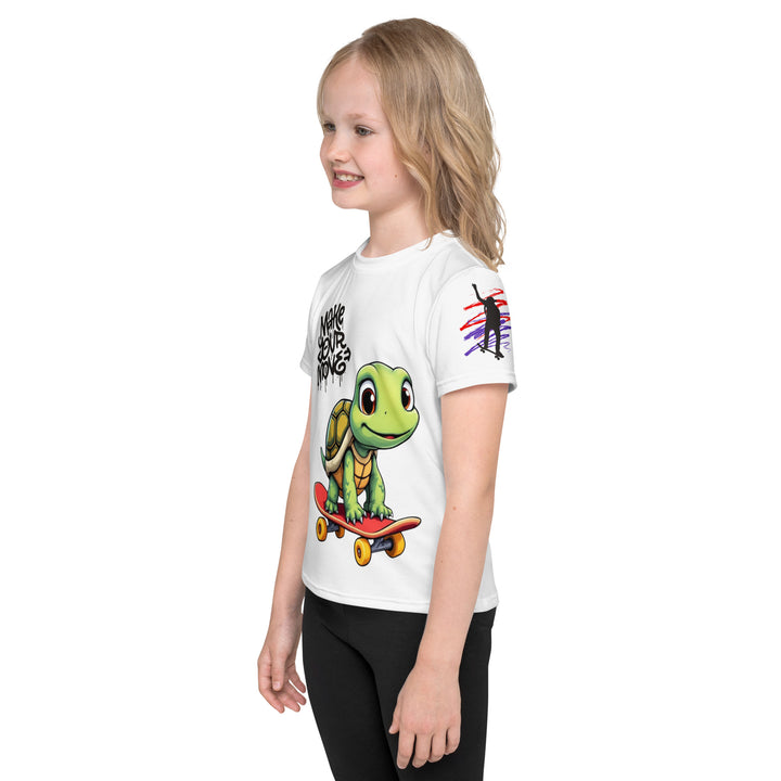Skater Turtle Girls T-shirt, white background with a green turtle on a skateboard and black "MAKE YOUR MOVE" text on the front, black skater silhouette with pink and purple motion lines on the left sleeve, and a skateboard with "SKATE" text at the bottom back of the shirt, left side view on model