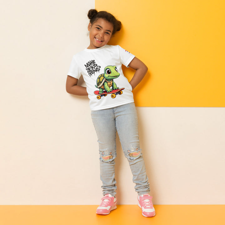 Skater Turtle Girls T-shirt, white background with a green turtle on a skateboard and black "MAKE YOUR MOVE" text on the front, black skater silhouette with pink and purple motion lines on the left sleeve, and a skateboard with "SKATE" text at the bottom back of the shirt, relaxed front pose on model