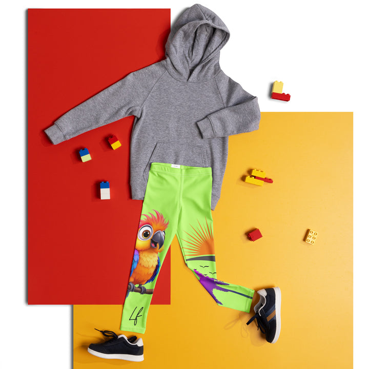 Sunset Parrot Girls Leggings, neon green background with an orange, blue, and purple parrot standing on a branch on one leg, and an orange sunset with flying birds and a purple palm tree on the other leg, front view laid flat on floor