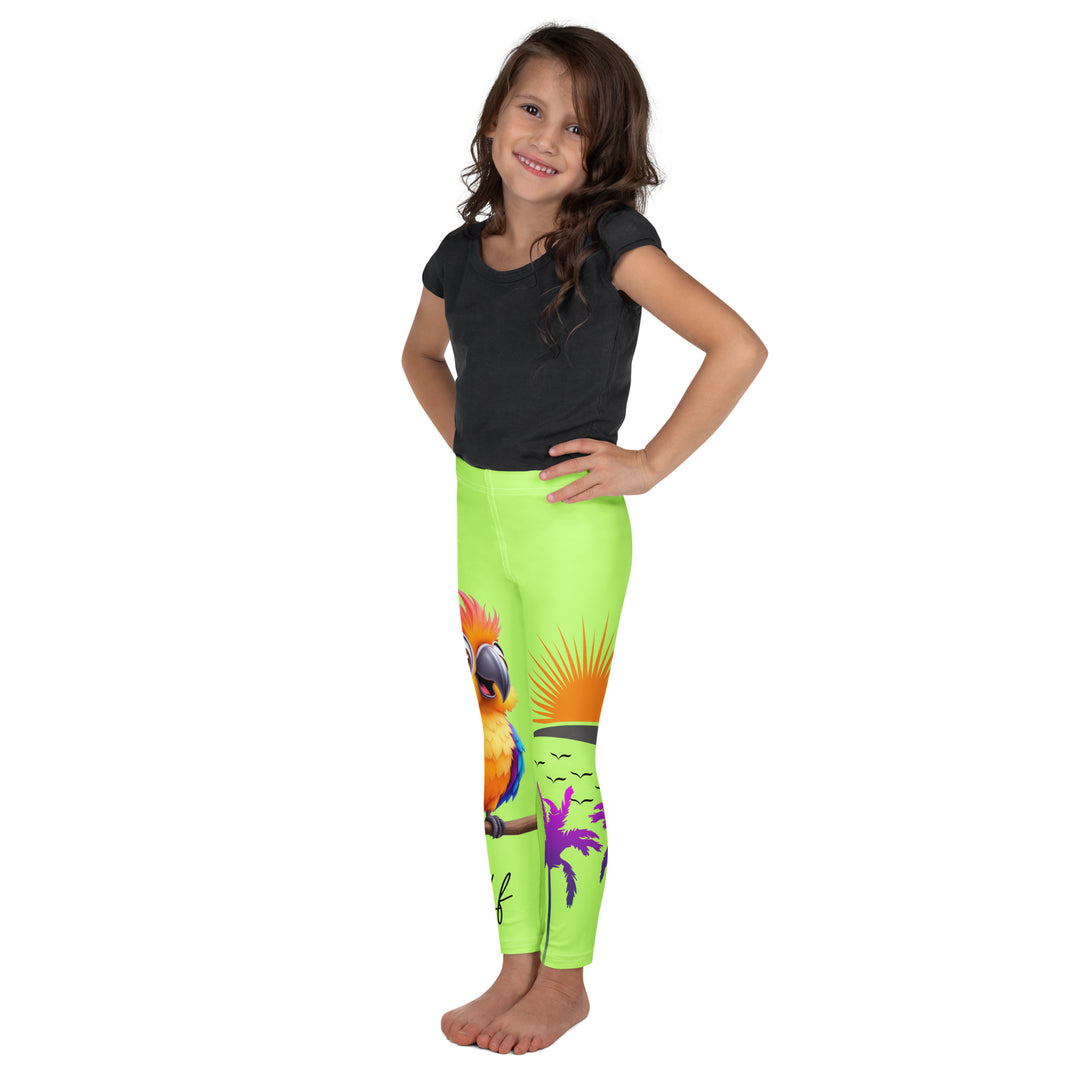  Sunset Parrot Girls Leggings, neon green background with an orange, blue, and purple parrot standing on a branch on one leg, and an orange sunset with flying birds and a purple palm tree on the other leg, left side view on model