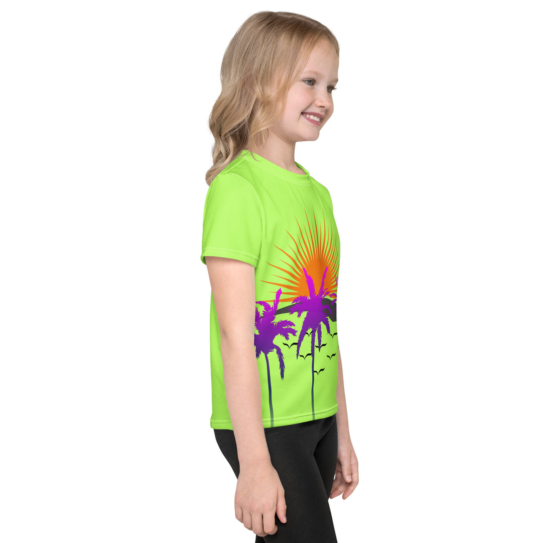  Sunset Parrot Girls T-shirt, neon green background with an orange sunset, flying birds, and three purple palm trees on the front, and an orange, purple, and blue parrot standing on a branch on the back, right side view on model