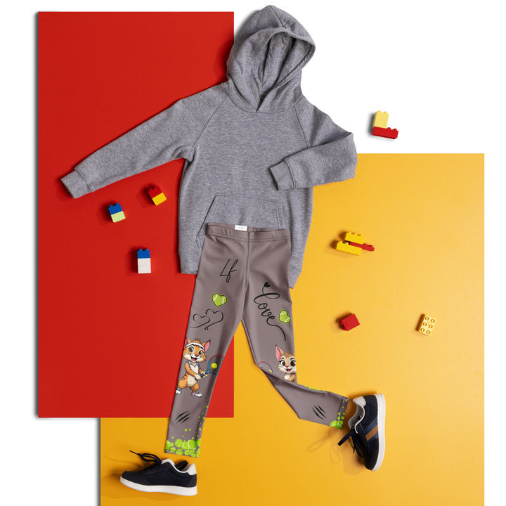 Tennis Kittens Girls Leggings, dark gray background with a cat holding a tennis racket on one leg and a kitten with a tennis racket on the other leg, each racket with a tennis ball as if playing, dressed in sporty outfits, with neon green tennis balls, hearts, and "love" text, front view laid flat on floor